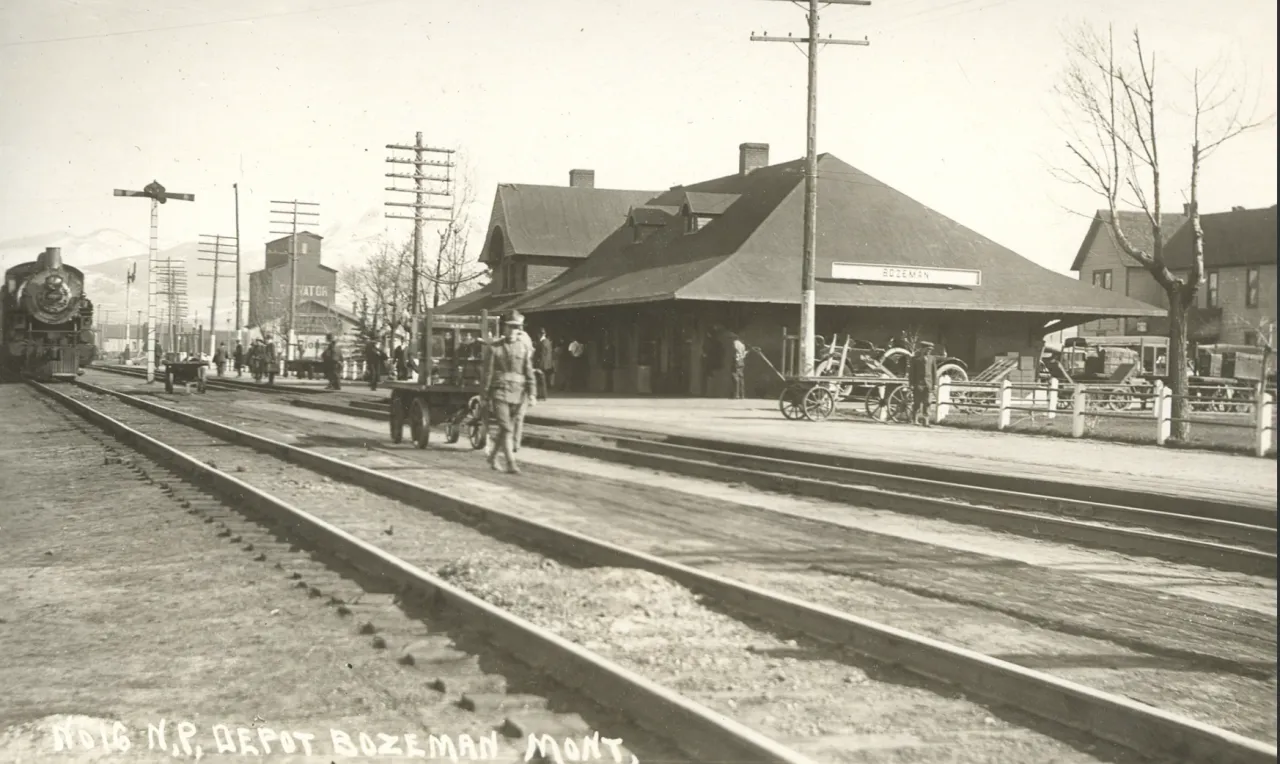 Historic Northern Pacific depot in Bozeman, with railroad tracks and the Bridgers beyond.